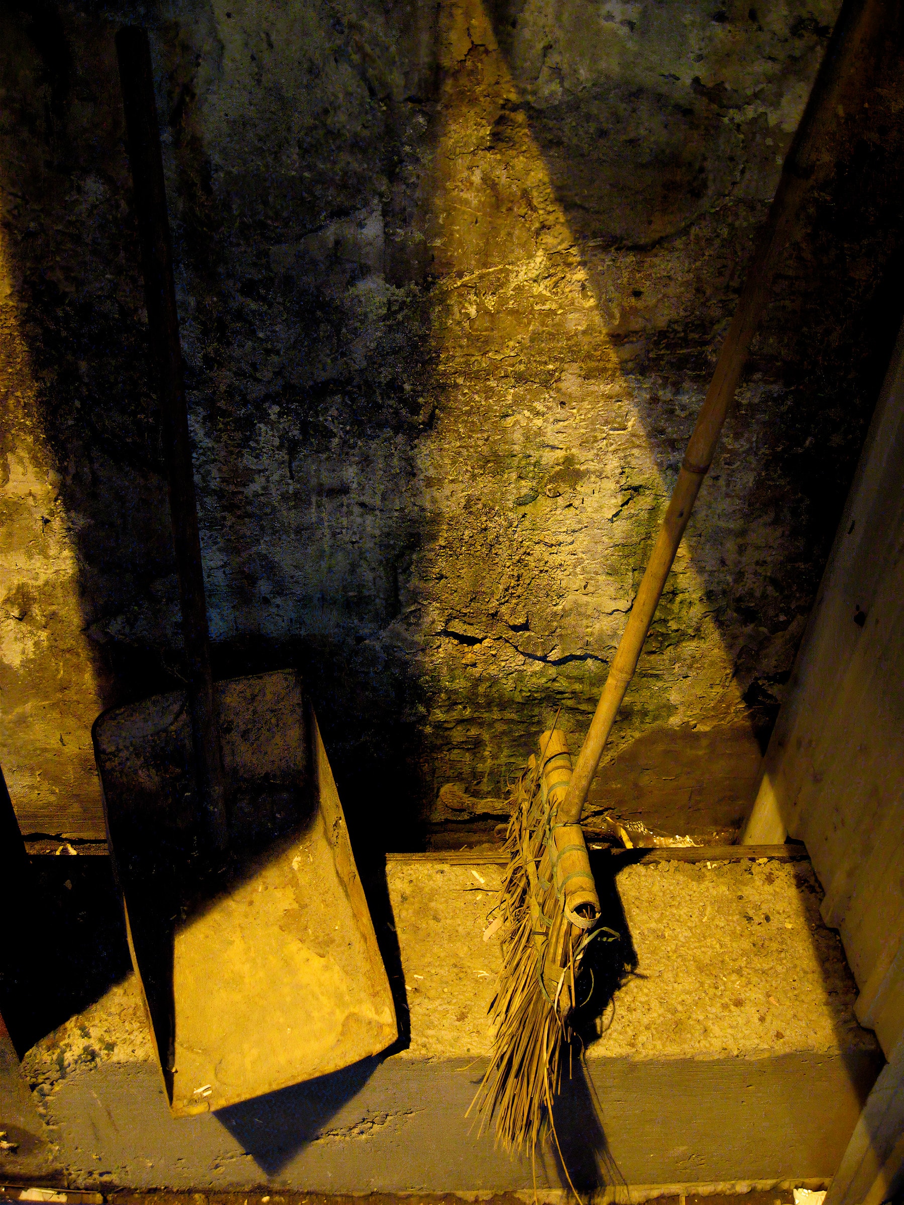 Broom and dustpan in underground space with yellow light