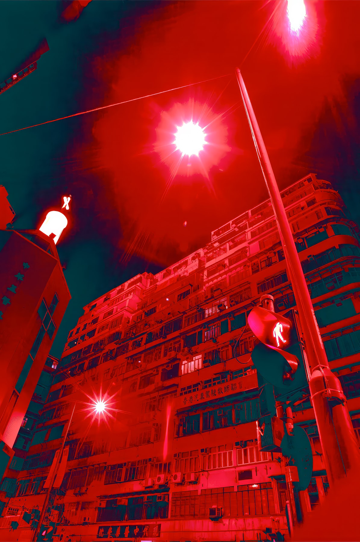 Looking up at Hong Kong tenement building bathed in deep red light with traffic signal