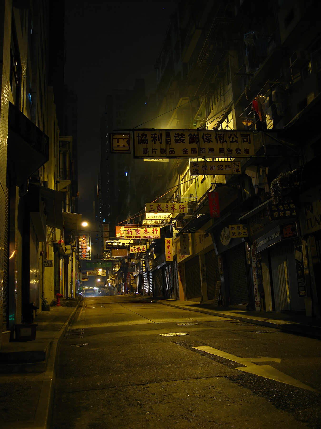Empty Hong Kong timber street at night with overhanging Chinese shop signs